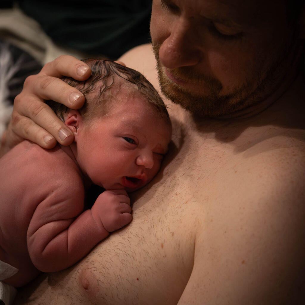 Papa met pasgeboren baby tijdens gouden uurtje